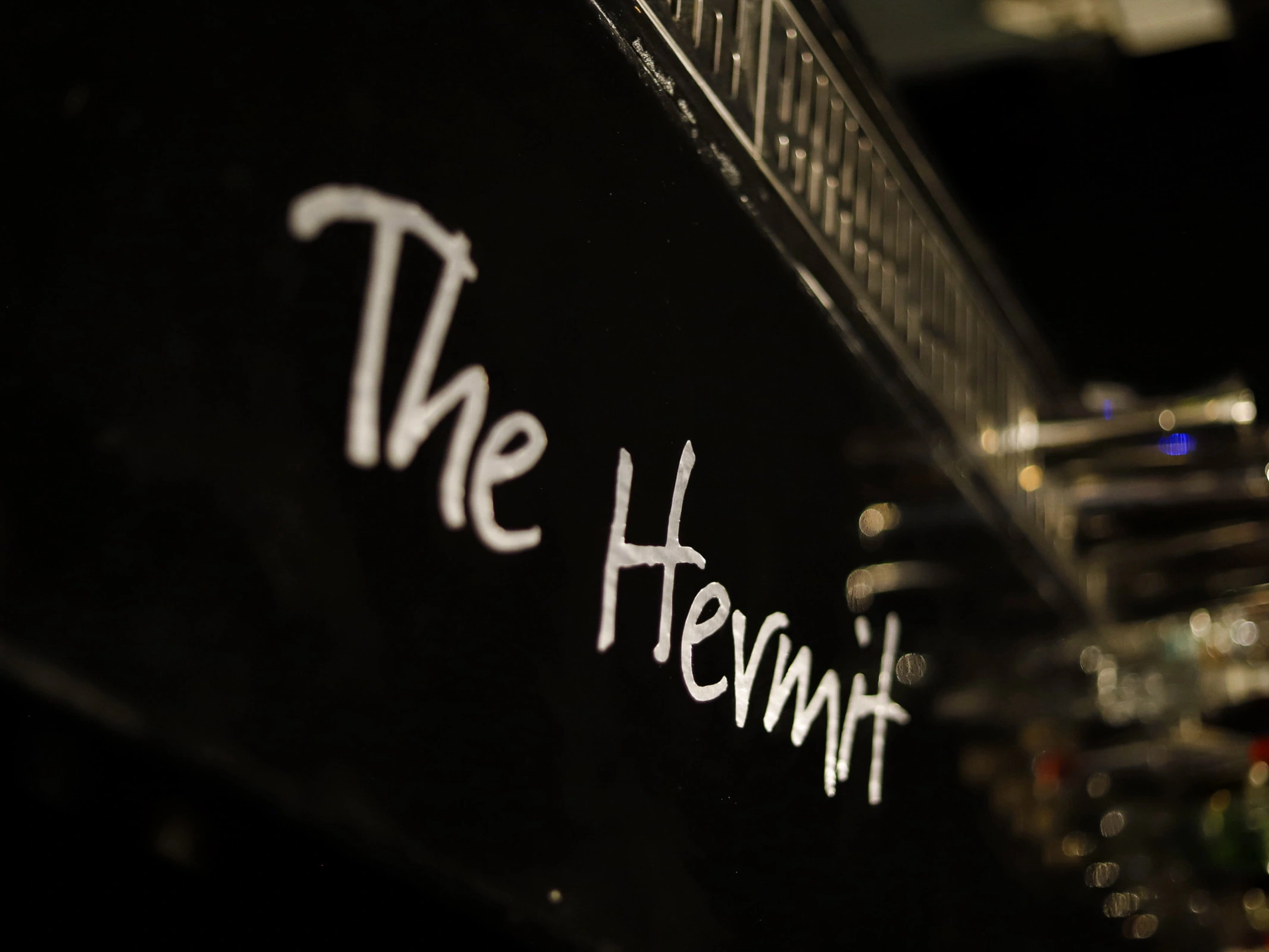 The Hermit Cocktail Bar counter with premium spirit bottles, cocktail preparation station and warm amber lighting